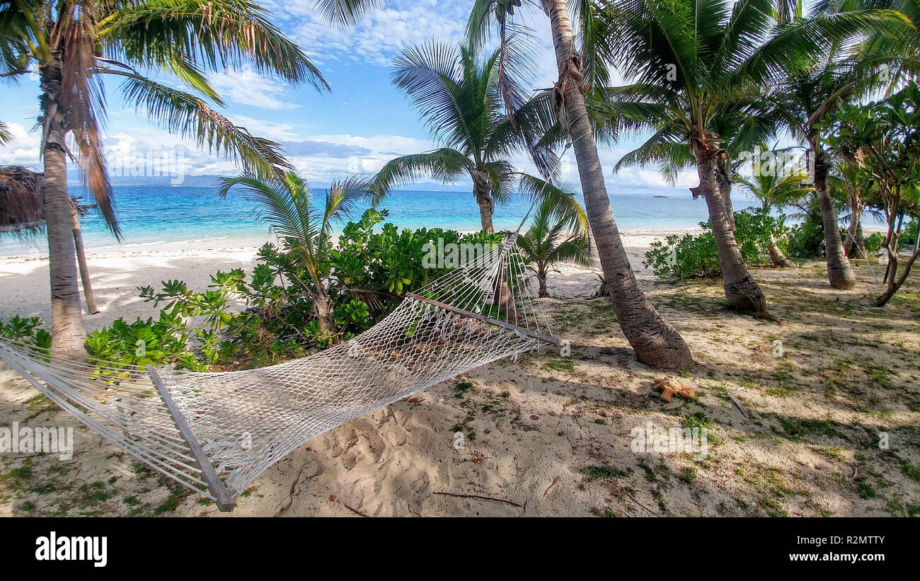 Hängematte am Strand, umgeben von Palmen, Fidschi Stockfoto