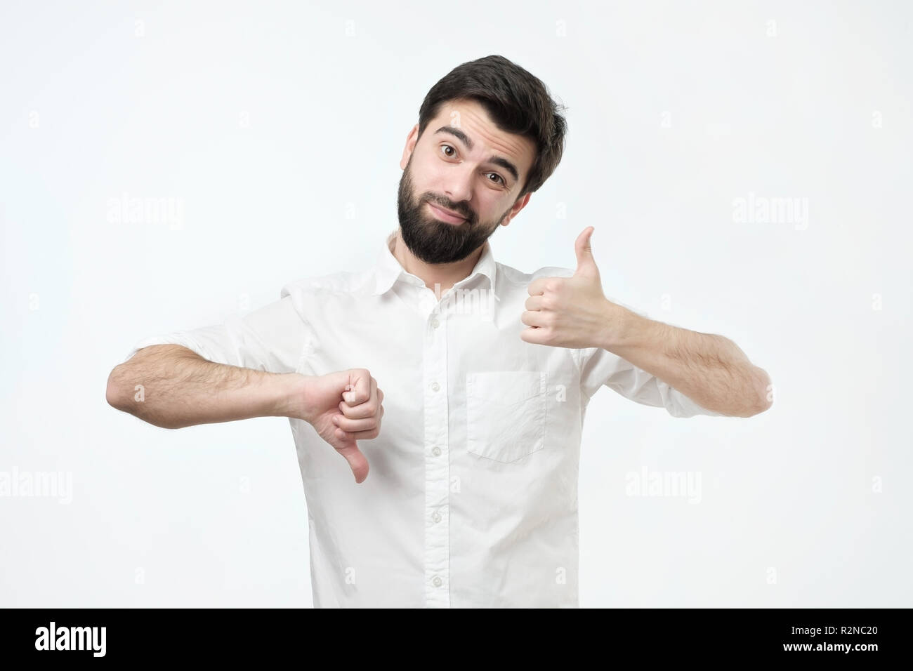 Mann, der versucht, eine Entscheidung, gutes oder schlechtes Zeichen zu machen. Stockfoto