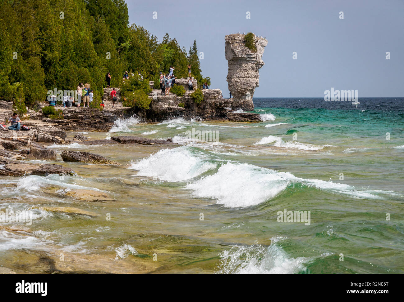 Gruppe von Besuchern genießen Blumentopf Insel mit Wellen am Ufer von Fathom Five National Marine Park in Tobermory, Ontario, Kanada Stockfoto Gruppe von Besuchern genießen Blumentopf Insel mit Wellen am Ufer von Fathom Five National Marine Park in Tobermory, Ontario, Kanada Stockfoto