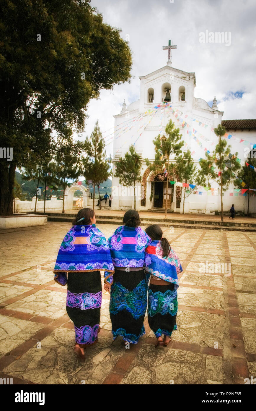 Traditionell gekleidete Damen zu Fuß über die Plaza in Zinacantan, Chiapas, Mexiko. Stockfoto