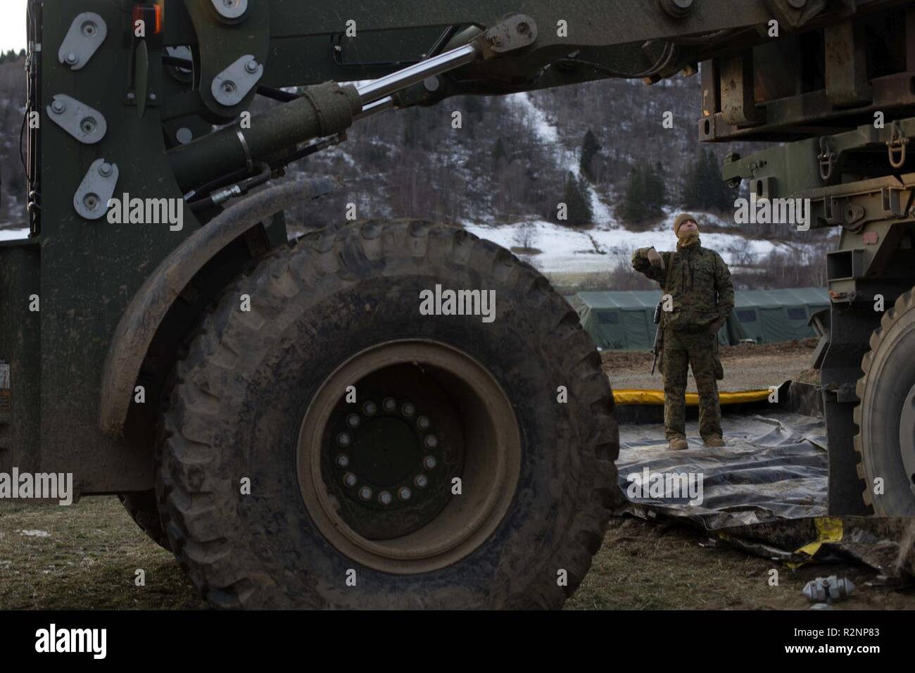 Us Marine Corps Cpl. Matthew James, mit Transport Services Unternehmen, die Bekämpfung der Logistik Bataillon 2, leitet ein Traktor, Gummi-müde, artikuliert, Mehrzweckfahrzeug, lädt es eine sechs Behälter voll, Norwegen, Okt. 30, 2018. Die Marines geladen, Treibstoff, Ausrüstung und Verpflegung, bereit, auf Logistik System des Fahrzeugs Ersatz- und mittlere taktische Fahrzeug Ersatzteile resupply 2nd Marine Division in Oppdal und Hjerkinn während der Übung Trident Zeitpunkt 18 Essen. Die Übung verbessert die USA und die NATO-Verbündeten und Fähigkeiten der Partner zur Zusammenarbeit militärische Operation durchzuführen Stockfoto