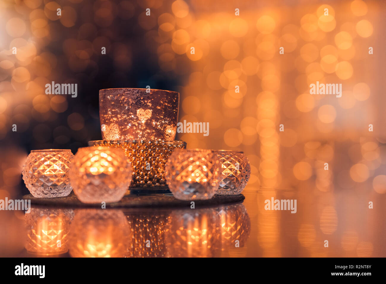 Gemütliches Innendekor, brennende Kerzen in Brillen mit verschwommenem romantischen Lichterhintergrund. Weihnachten oder Winter Saison Herbst Heim Interieur Stockfoto