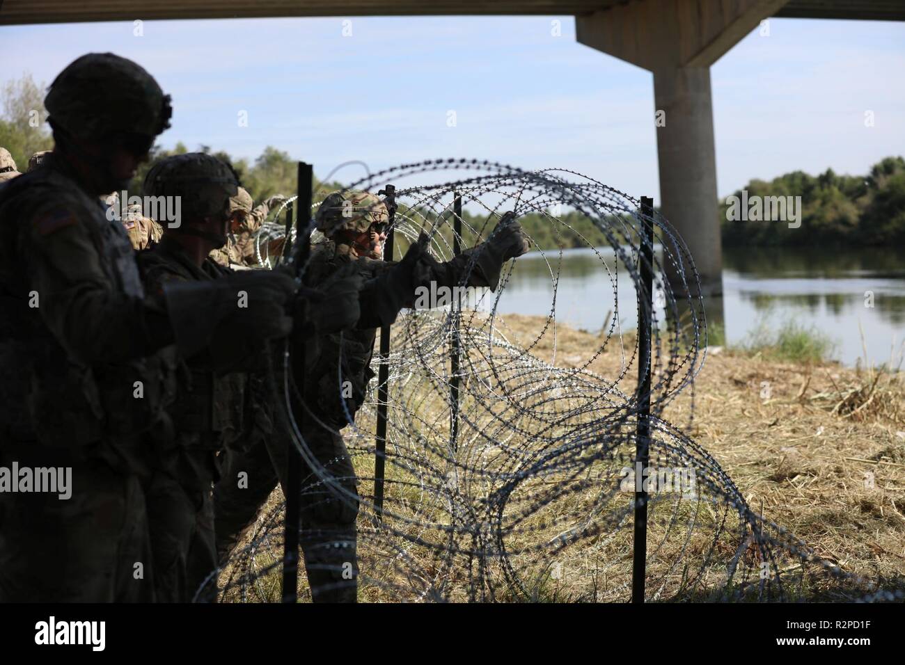 Soldaten concertina Draht in eine Position entlang der südwestlichen Grenze der Vereinigten Staaten in der Nähe von Hidalgo, Texas bereitstellen. Us-Armee Norden ist unter der Aufsicht des US Northern Command an der südwestlichen Grenze das Ministerium für Heimatschutz und der Zoll und Grenzschutz Mission der Grenze zu unterstützen. November 2, 2018. Stockfoto