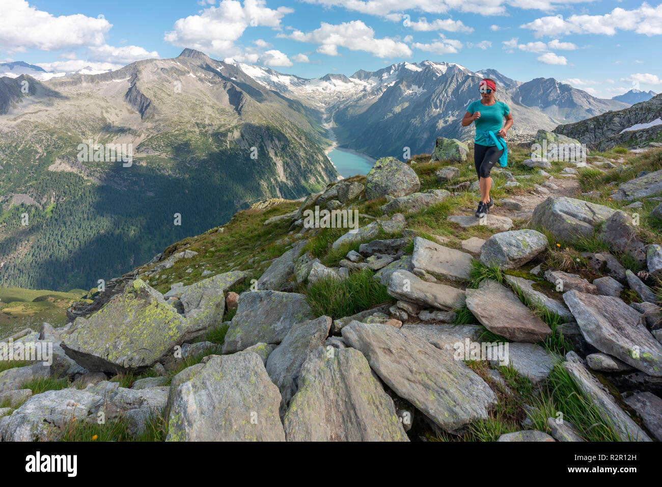 Junge Frau runner auf dem Weg zwischen olperer Hütte, friesenberg Haus, Zillertaler Alpen, Tirol, Schwaz Bezirk, Österreich Stockfoto