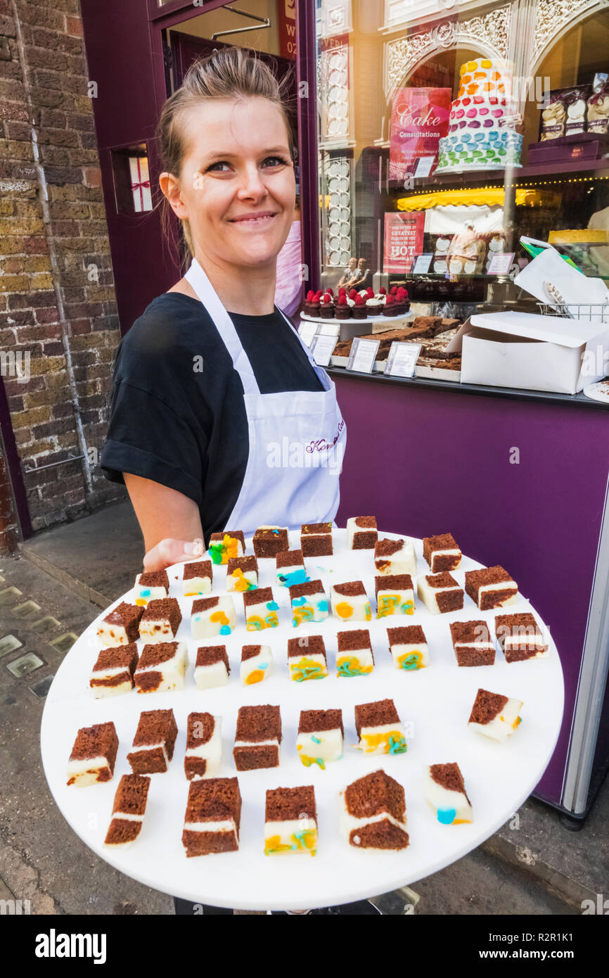 England, London, Southwark, London Bridge City, Borough Markt, Cake Shop Verkauf Mädchen bietet kostenlose Proben Stockfoto