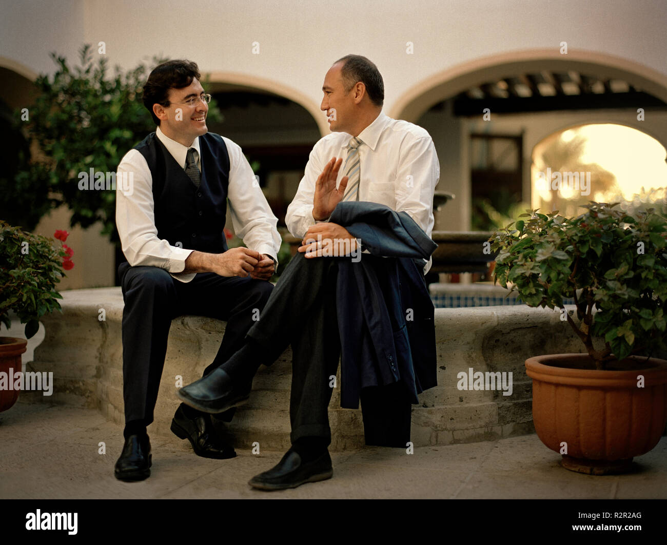 Zwei Geschäftsleute ein Gespräch haben, wie Sie in der Nähe der Brunnen sitzen. Stockfoto