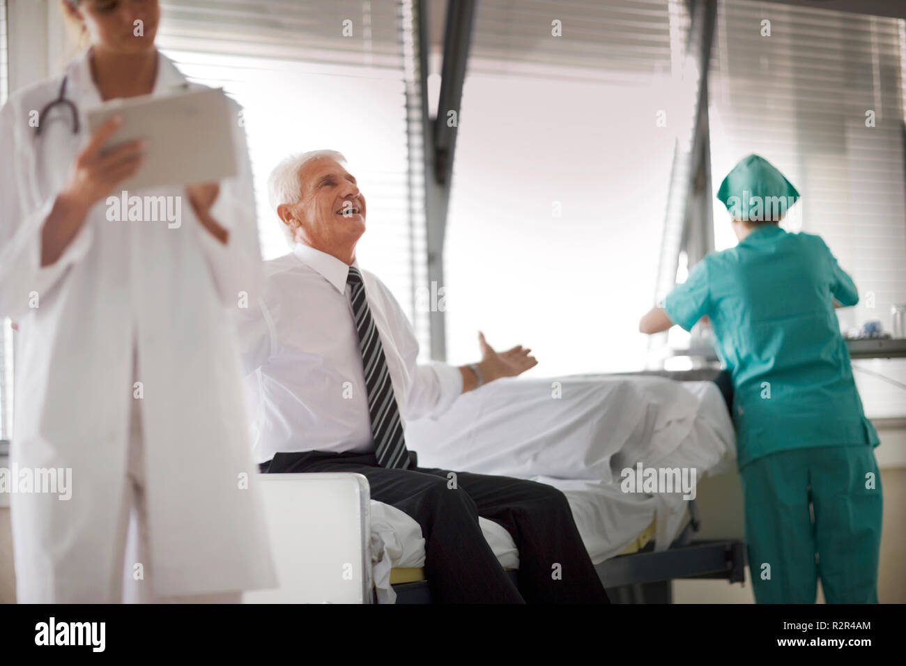 Blick auf ein Mann saß auf einem Bett mit medizinischer Versorgung. Stockfoto