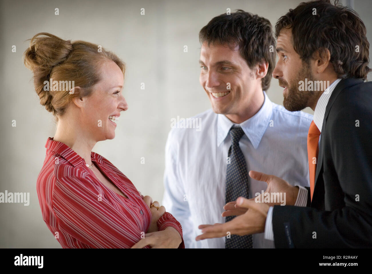 Blick auf eine Geschäftsfrau auf zwei Geschäftsmänner lächelnd. Stockfoto