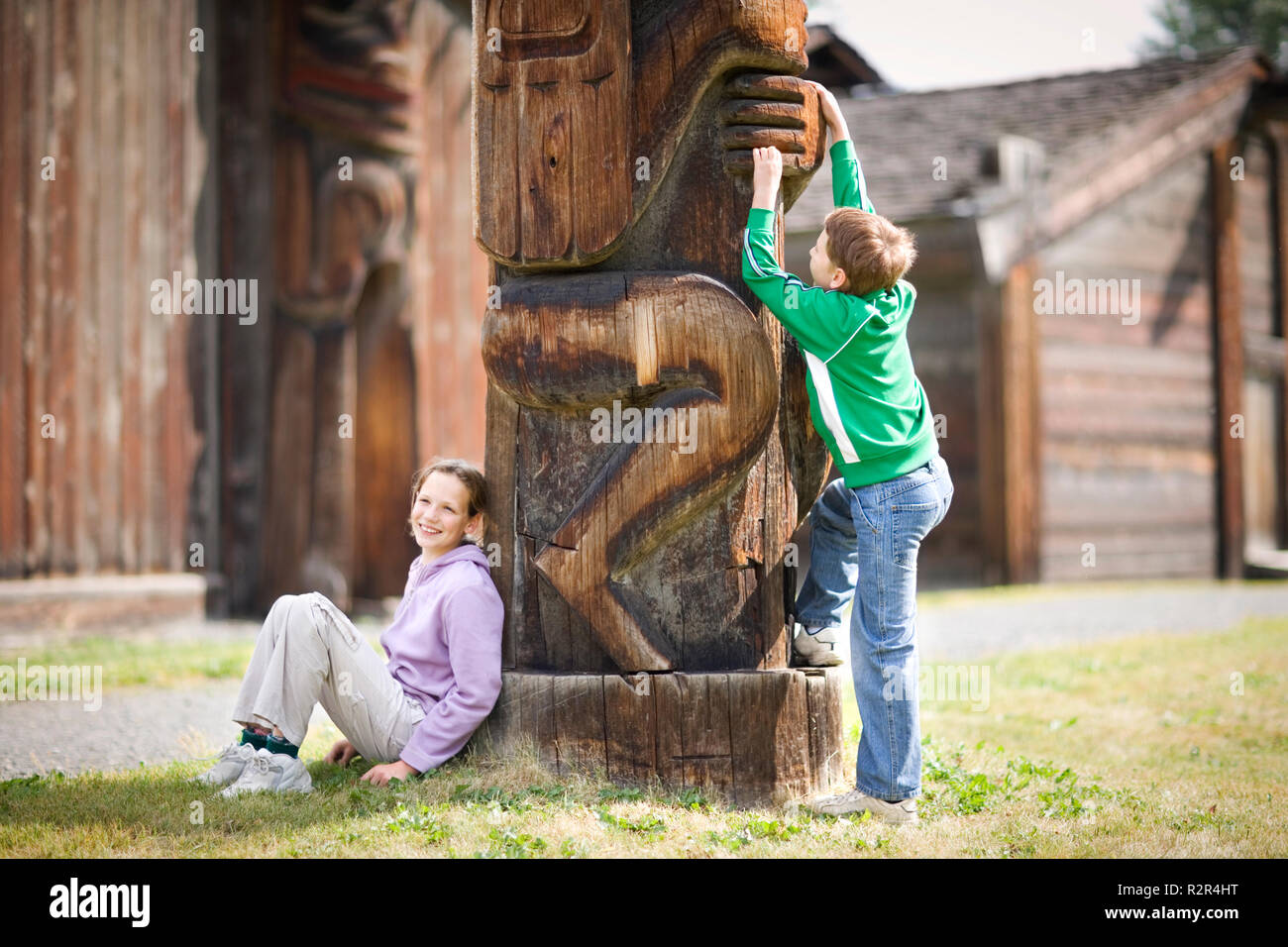 Zwei Kinder neben einem Totempfahl. Stockfoto