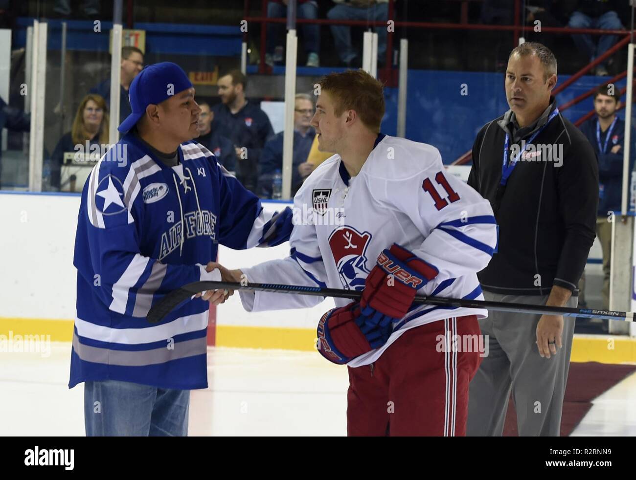 Oberstleutnant Lawrence Yazzie (links), 132 d Cyber Operations Squadron Commander, schüttelt Hände mit Des Moines Buccaneers Hockey Spieler Luke Manning, 4. November 2018 in Des Moines, Iowa. Manning hat der Air Force Academy verpflichtet. Stockfoto