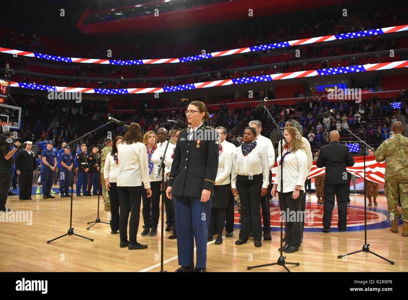 Michigan Army National Guard Soldat SPC. Samantha Hall und der Detroit Arsenal Einheit Team Chor sang die Nationalhymne auf der Detroit Pistons' Hoops für Spiel Truppen gegen die Miami Heat 5. November an der Little Caesars Arena in Detroit, Michigan. Spc. Hall hatte bereits Erfahrung in der musikalischen Theater vor dem Ehrenamt vor dem Spiel zu singen. Stockfoto
