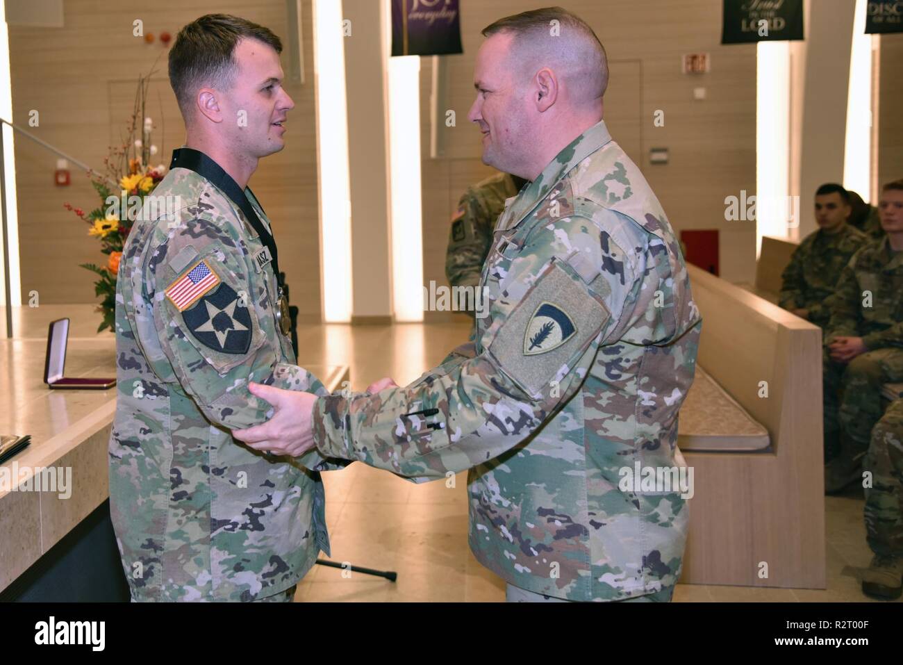 Sgt. Maj. David Clark, die US-Army Europe chief für religiöse Angelegenheiten Sergeant Major, stellt Personal. Sgt. Aaron Madasz, 2.Kavallerie Regiments, mit der ersten Staff Sgt. Christopher Stout Medal unterzeichnet durch den Leiter der Kapläne, November 7, 2018. Stockfoto