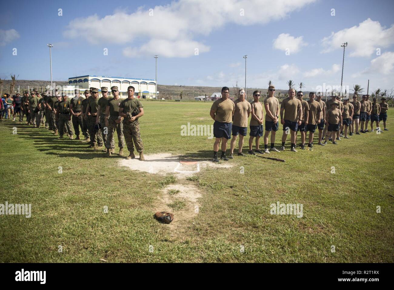 Marines mit Combat Logistik Bataillon 31 und Segler mit Naval Mobile Konstruktion Bataillon 1 stehen im Einklang mit einer Community Relations baseball Ereignis während der US-Verteidigung Unterstützung der zivilen Behörden Hilfsmaßnahmen auf Tinian, Commonwealth der Nördlichen Marianen, November 9, 2018. Unternehmen, staatliche Gebäude, Häuser und Schulen wurden stark von Super Typhoon Yutu, die einen direkten Treffer mit verheerenden Auswirkungen auf Tinian Okt. 25 wie der zweitstärkste Sturm zu je US-Boden Hit gemacht beschädigt. Marines mit dem 31 Marine Expeditionary Unit und zur Bekämpfung der Logistik Bataillon 31 kamen am Tinia Stockfoto