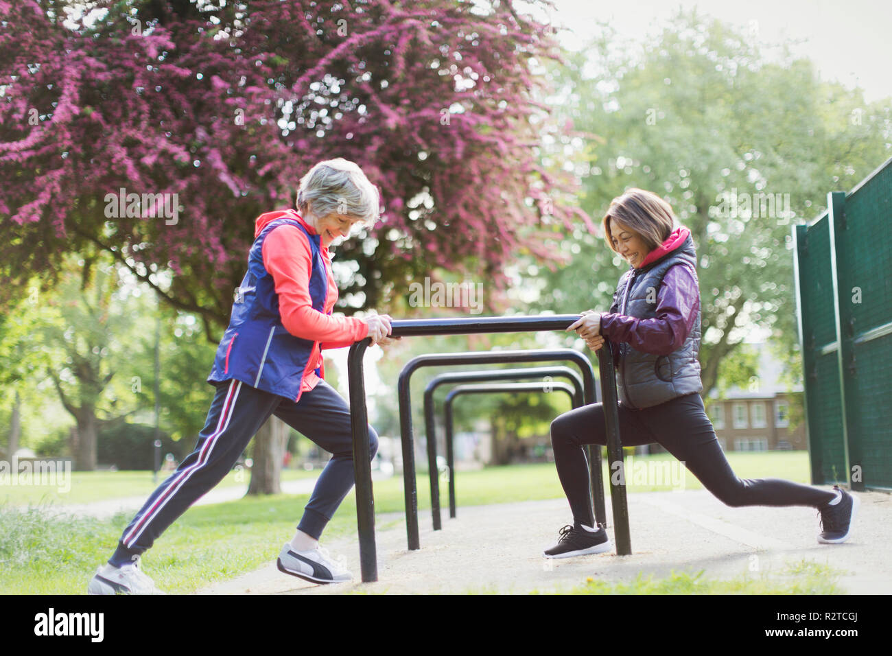 Active Senior Läuferinnen stretching Beine in Park Stockfoto