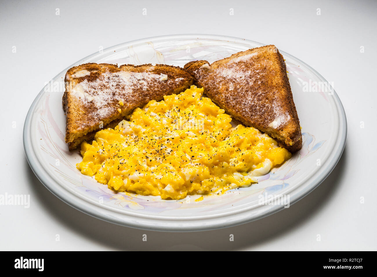 Rührei zwei gebuttertem Toast Weizen Stockfoto