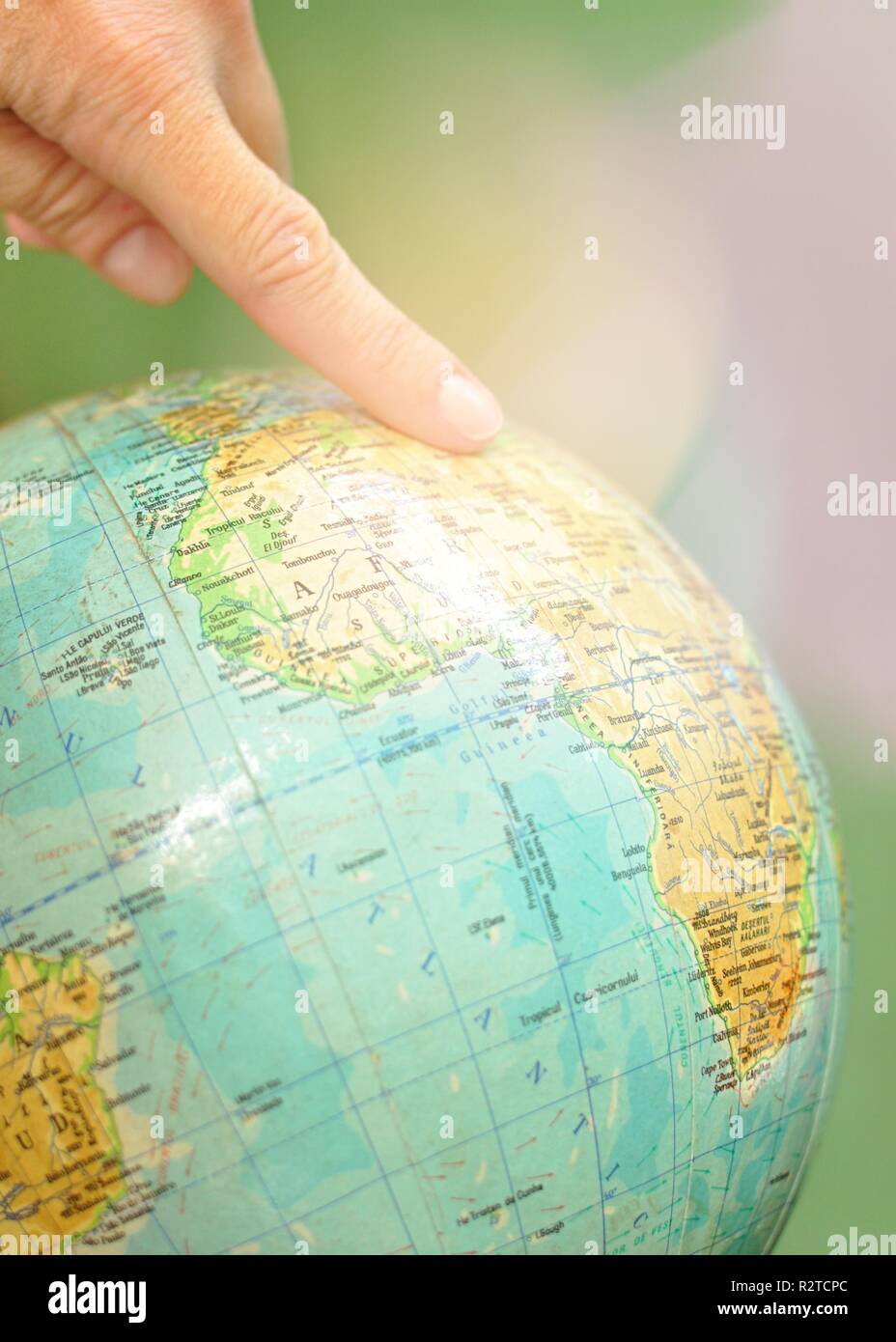 Nahaufnahme eines Globus Weltkarte mit dem Zeigefinger auf ihn. Konzept der Reisen, erkunden oder die Suche nach dem Zielort Stockfoto
