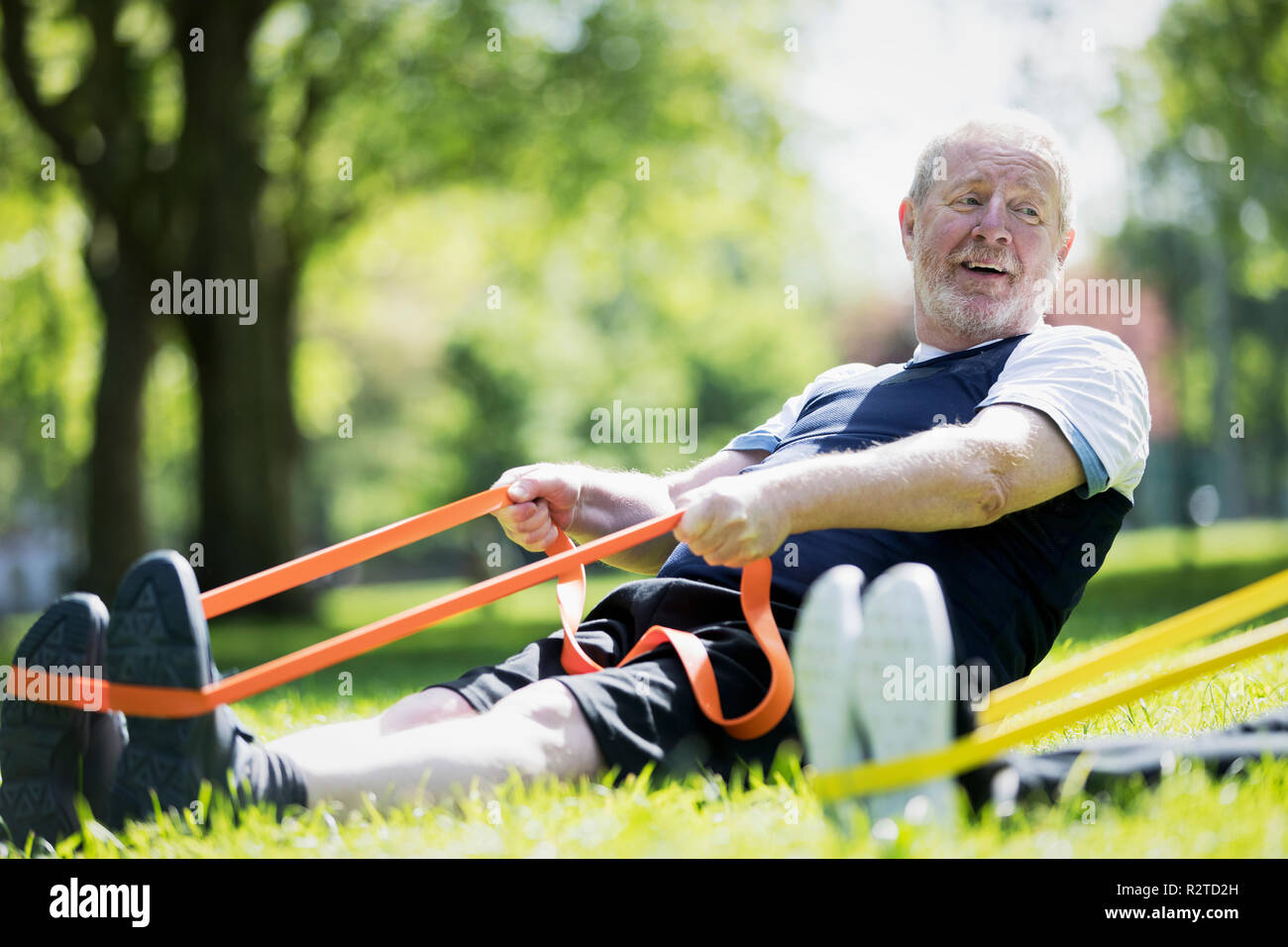 Active Senior mann Training in Park, Stretching mit Widerstand Band Stockfoto