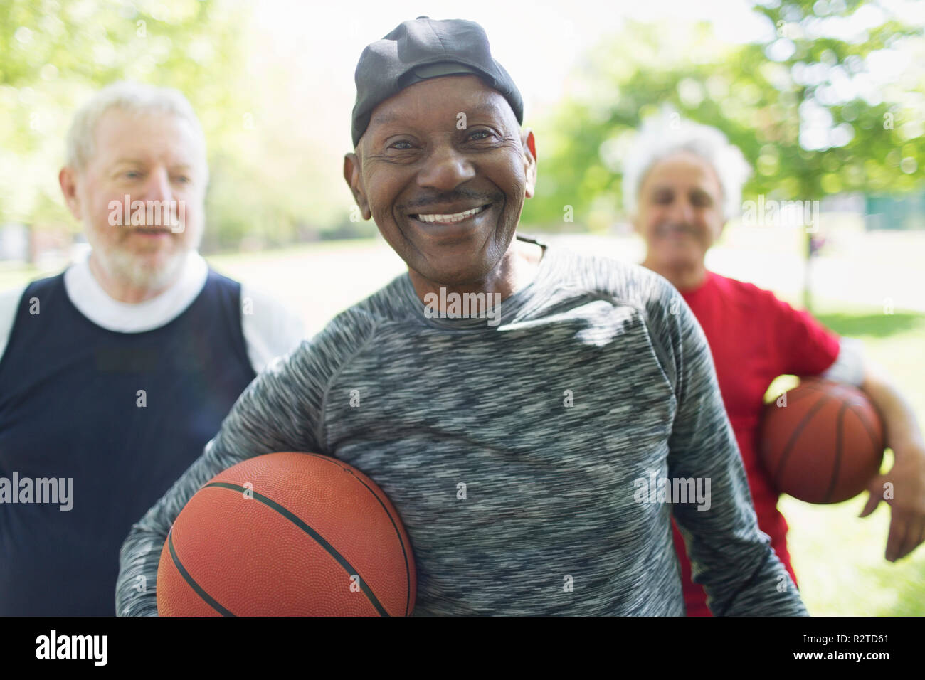 Portrait zuversichtlich, lächelnd Aktive ältere Männer Freunde mit basketbälle in Park Stockfoto
