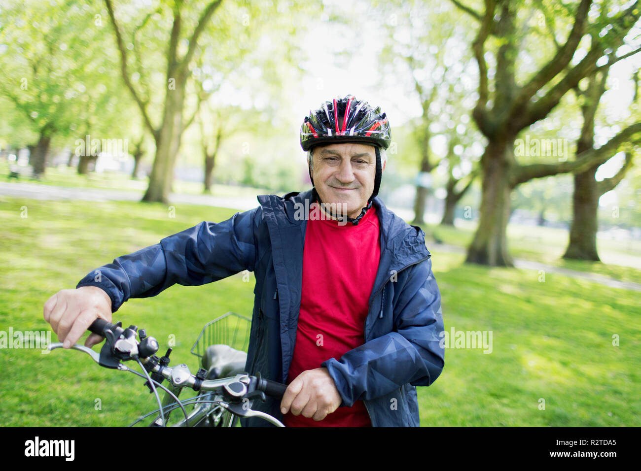 Portrait zuversichtlich Active Senior Mann reiten Fahrrad im Park Stockfoto