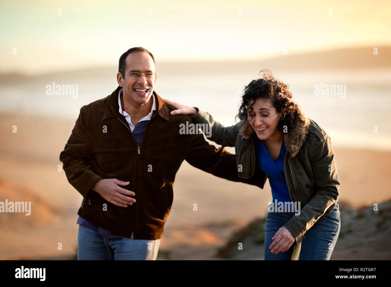 Lachen Mitte nach paar stehen zusammen auf einem Strand. Stockfoto