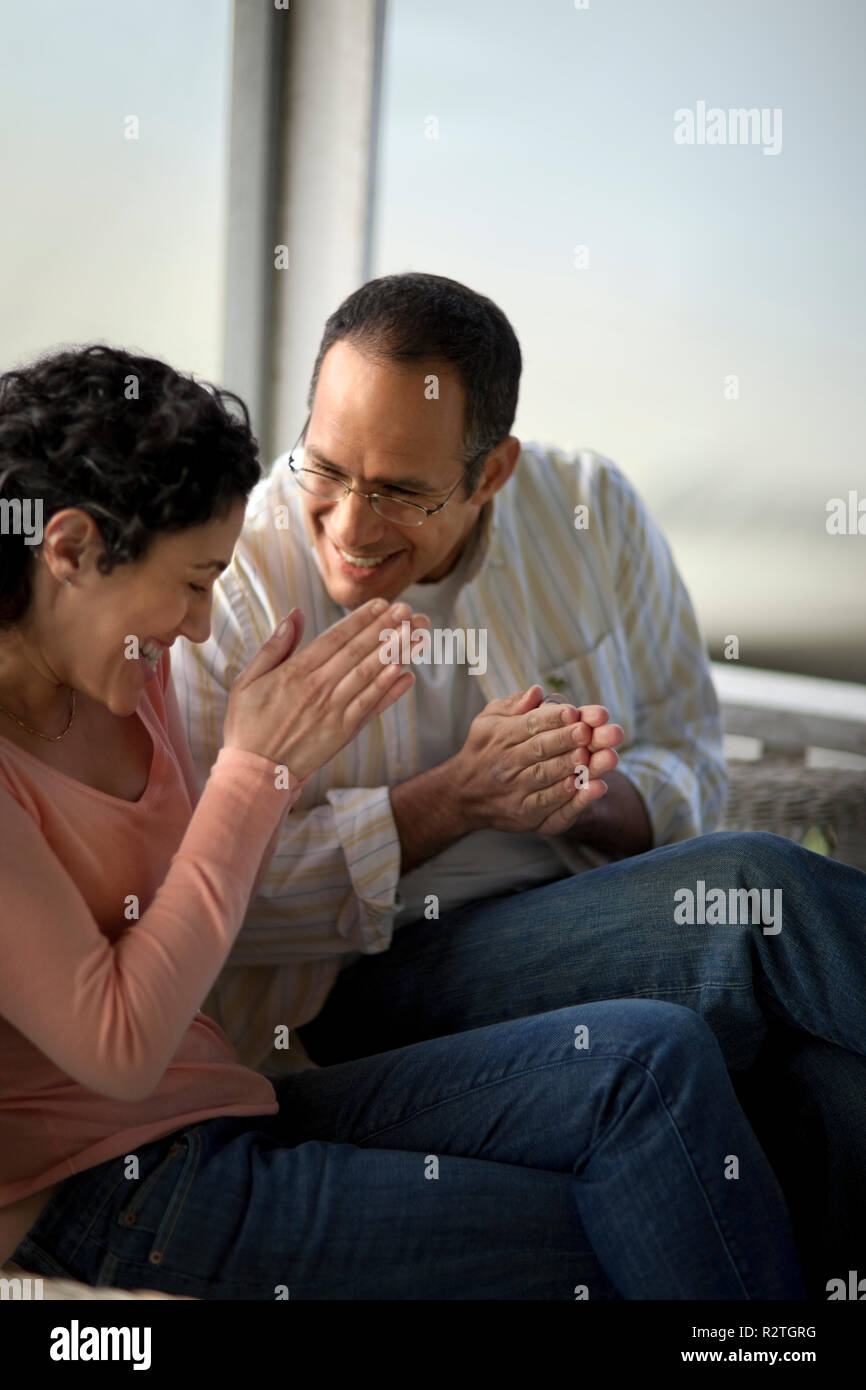 Gerne Mitte nach paar sitzt auf einer Veranda. Stockfoto