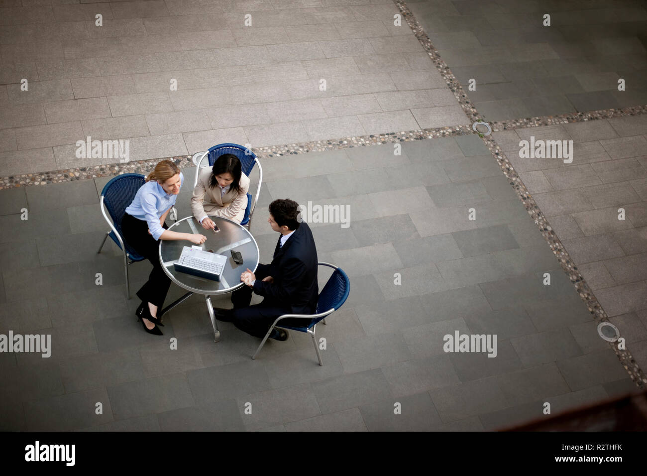 Drei Kollegen an einen Tisch draußen mit einem Laptop sitzen. Stockfoto
