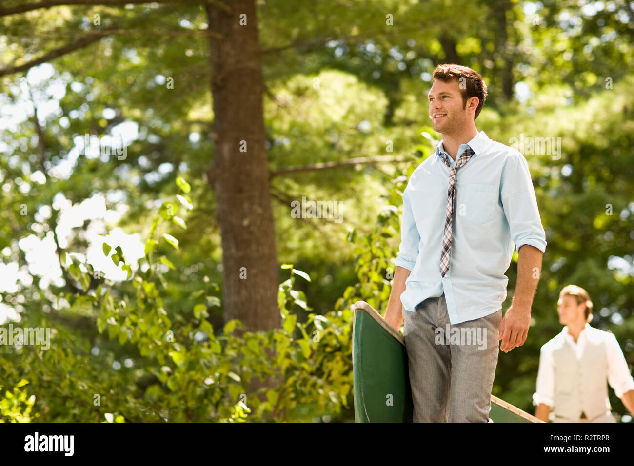 Zwei männliche Freunde mit einem Kanu durch den Wald. Stockfoto