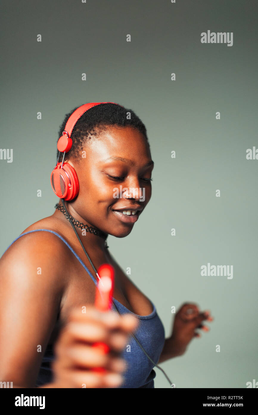 Unbeschwerte junge Frau mit Kopfhörer und MP3-Player tanzen Stockfoto