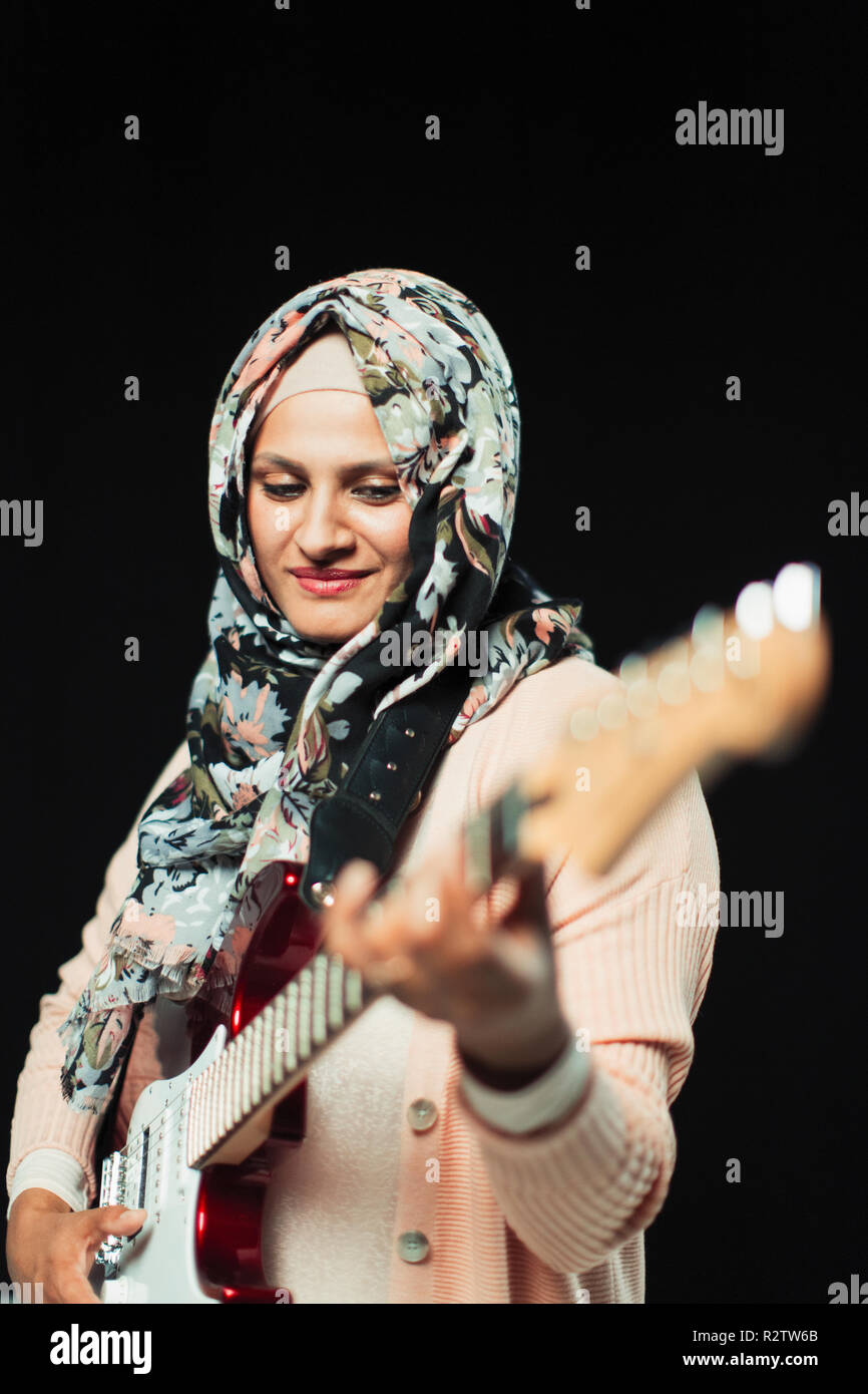 Frau in floralen Hijab spielen E-Gitarre Stockfoto