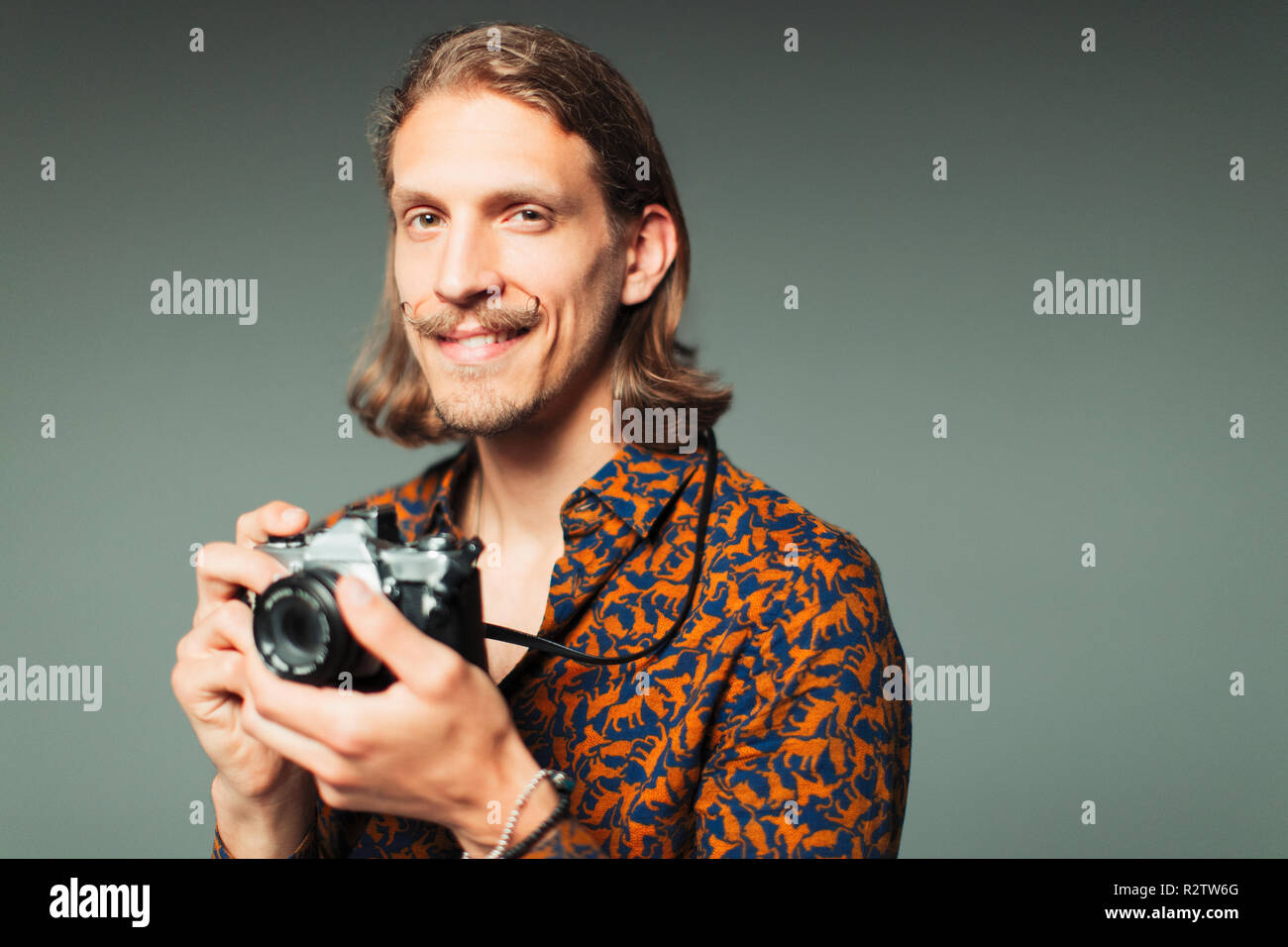 Portrait selbstbewussten jungen Mann mit Lenker Schnurrbart Holding retro Kamera Stockfoto