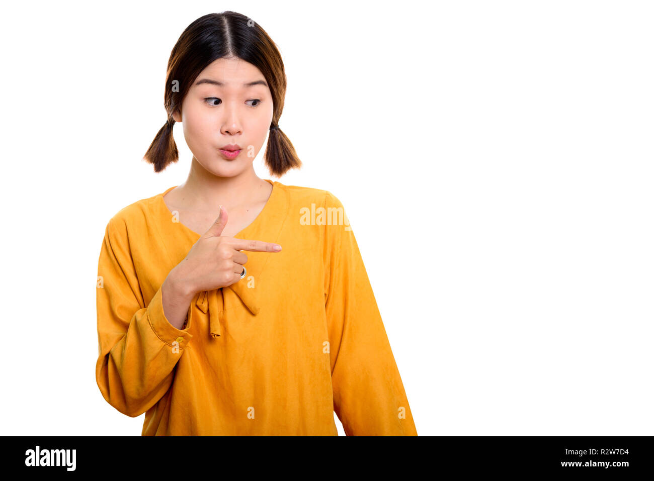 Studio shot der jungen schönen asiatischen Frau zeigt mit dem Finger zum Th Stockfoto