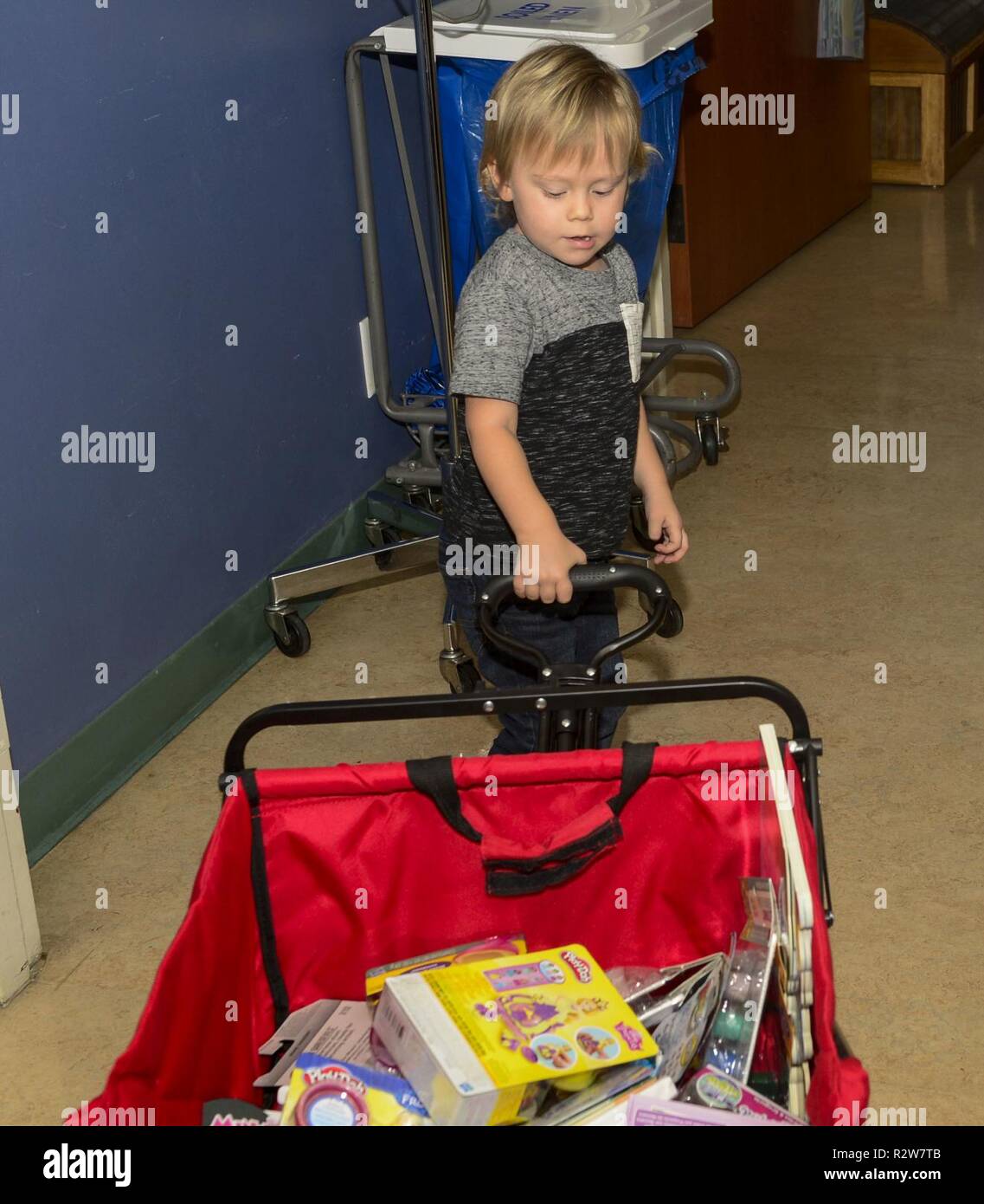 SAN DIEGO (Nov. 14, 2018) - Liam Weste, ein Patient an Naval Medical Center San Diegos (NMCSD) Pädiatrische Onkologie Abteilung, zieht seinen Wagen mit dem Spielzeug gefüllt, dass er plant, in der Gemeinde Spielzeugkiste in den Raum zu stellen. Liam und seine Familie waren die Vorteile eines jüngsten Geldbeschaffer und beschlossen, wieder in die Klinik, die so viel für sie getan hat. Liam wählte das Spielzeug, er glaubte, daß die Kinder möchte und setzte sie in die Spielzeugkiste für andere Kinder nach der Behandlung zu erhalten. Stockfoto