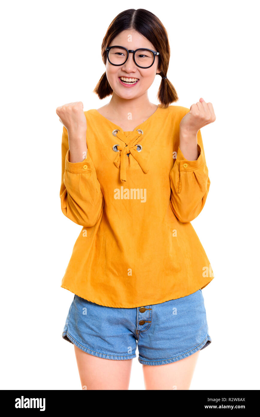Nachdenkliche junge asiatische Frau glücklich lächelnd, während sie aufgeregt Stockfoto