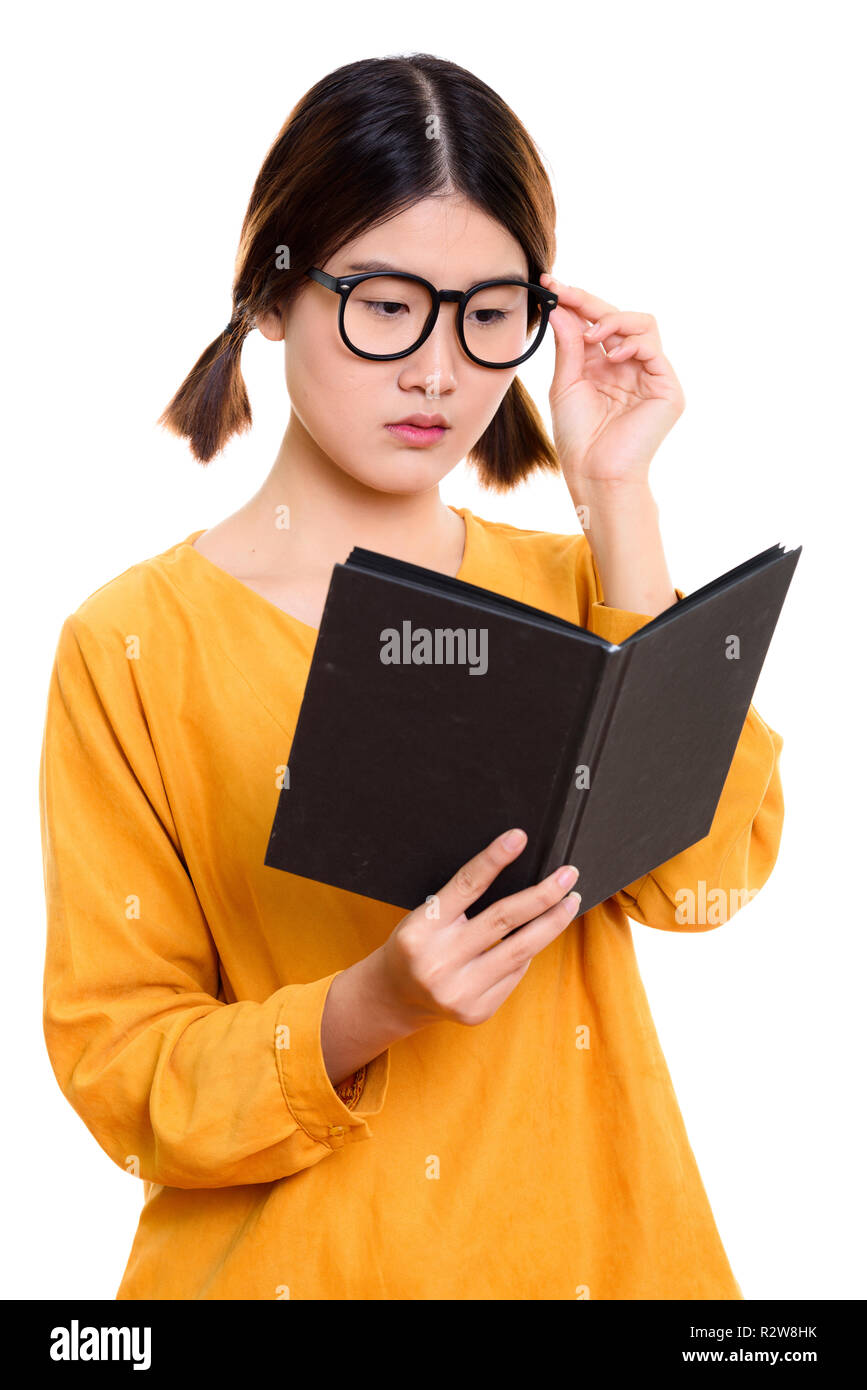 Junge schöne asiatische Frau mit Buch beim Halten eyeglasse Stockfoto