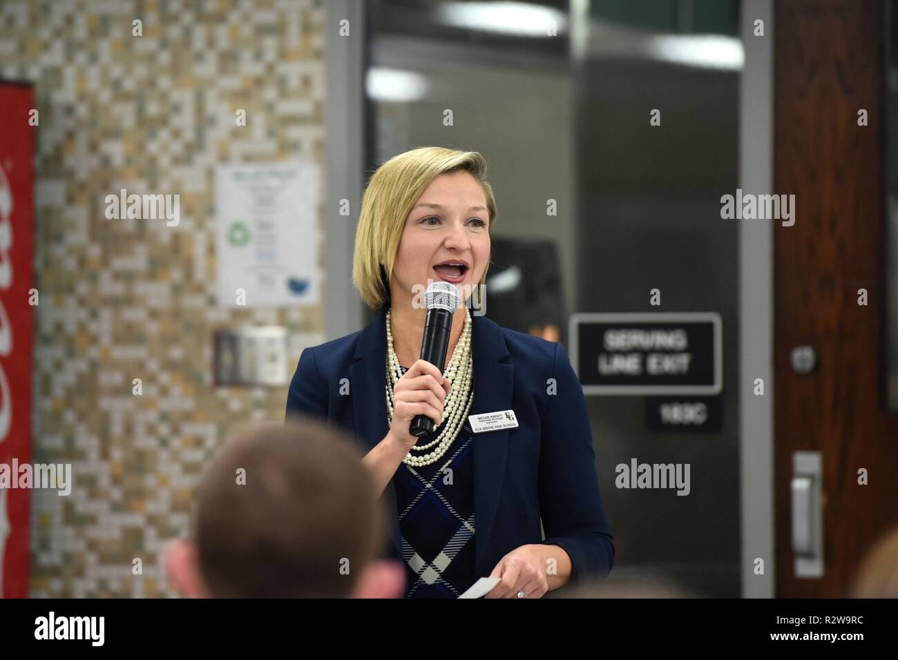 Megan Ritter, Associate Principal von Elk Grove High School, gibt Erläuterungen während der Elk Grove High School Veterans Day Zeremonie zu Ehren Veteranen aus den umliegenden Gemeinden, November 9, 2018. U.S. Army Reserve Brig. Gen. Kris A. Belanger, Kommandierender General, 85. Unterstützt den Befehl, war die Keynote Speaker für die Veranstaltung und sorgte mit Veteranen aus den einzelnen Service Filialen Weltkriegveteran, Al Mampre, die mit der berühmten Luftlandedivision Easy Company, 506th Infanterie Regiment gedient. Mampre Einheit Geschichte war auf der Mini-Serie "Band of Brothers". Werden Stockfoto