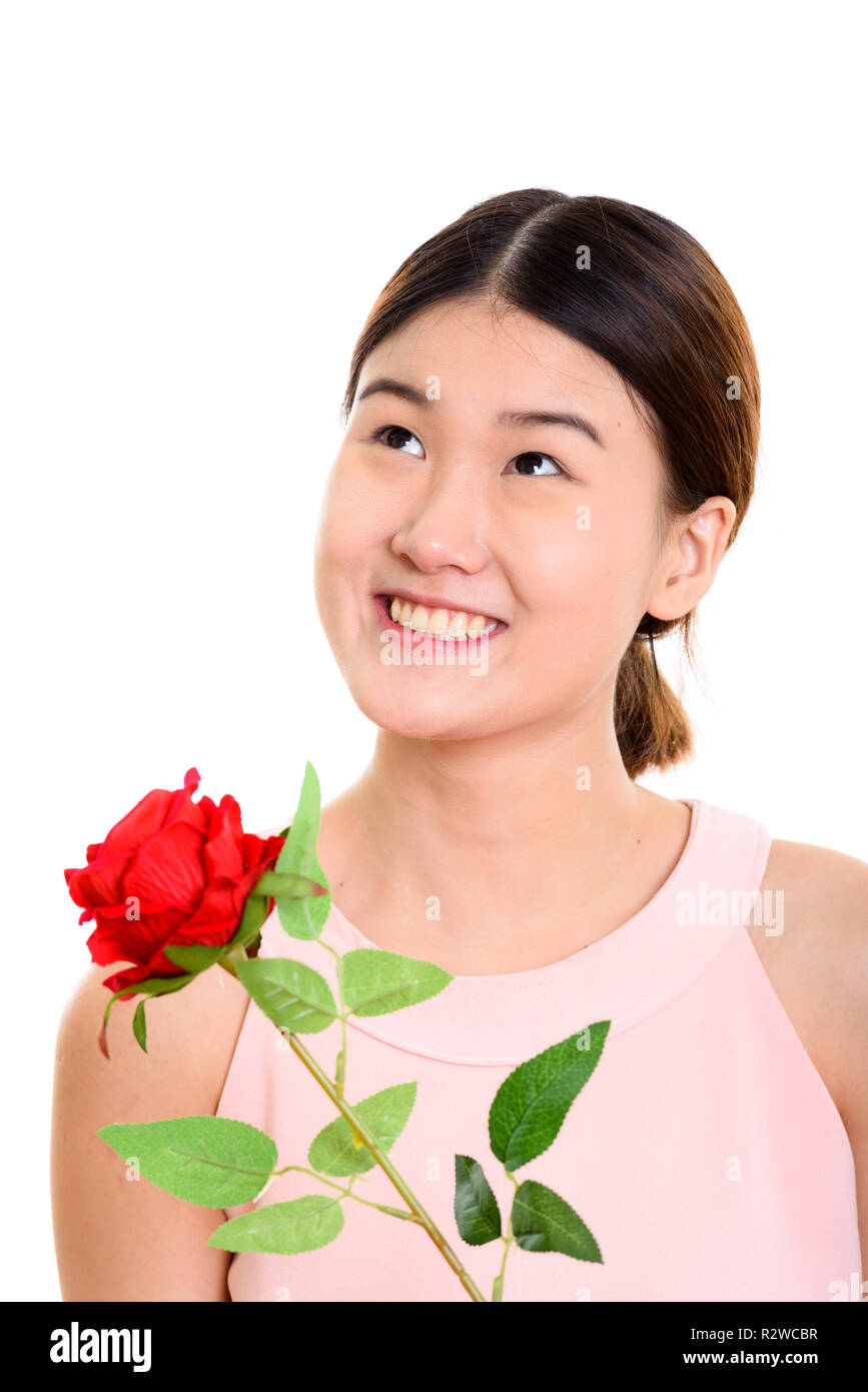Studio shot von jungen asiatischen Frau glücklich und lächelnd Rot r Stockfoto