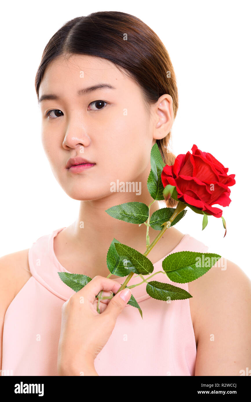 In der Nähe der Jugendlichen schöne asiatische Frau mit roten Rose in der Nähe von Th Stockfoto