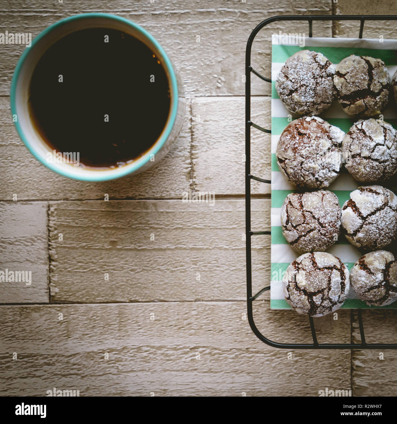 Schokolade crinkle Cookies in einem Korb mit einer Tasse Tee auf einem Holztisch. Ansicht von oben. Quadratischen Format. Stockfoto