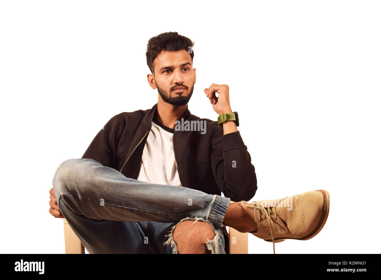 Schöner junge In schwarzer Jacke und zerrissenen Jeans sitzen, Pune, Maharashtra. Stockfoto