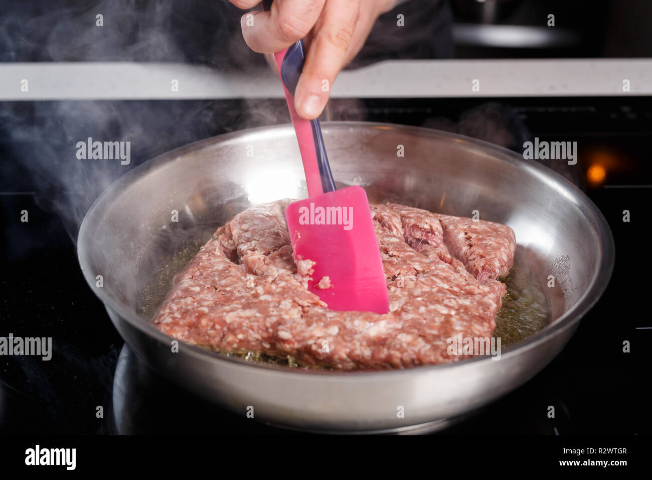 Koch Kochen Hackfleisch in eine Metallwanne Stockfoto