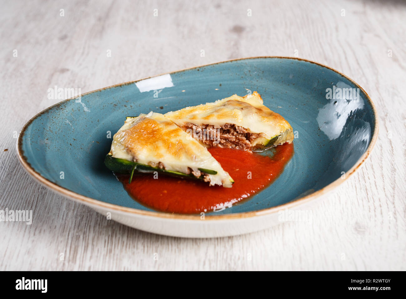 Gebackene Zucchini mit Hackfleisch und Käse überbacken mit Tomatensauce. Stockfoto