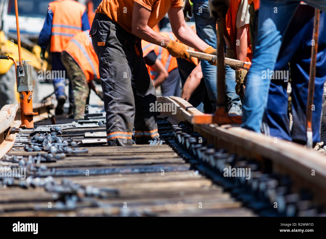 Arbeitnehmer in helle Uniformen legen, Eisenbahn- oder Straßenbahnschienen Stockfoto Arbeitnehmer in helle Uniformen legen, Eisenbahn- oder Straßenbahnschienen Stockfoto