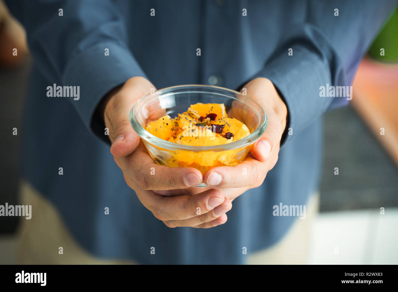 Gesundes Frühstück. Müsli mit Früchten und Samen. Mann mit Frühstück Stockfoto
