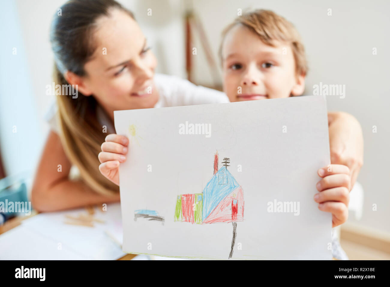 Kind mit Zeichnung der Traum Haus als Wunsch für die Familie vor dem Umzug Stockfoto