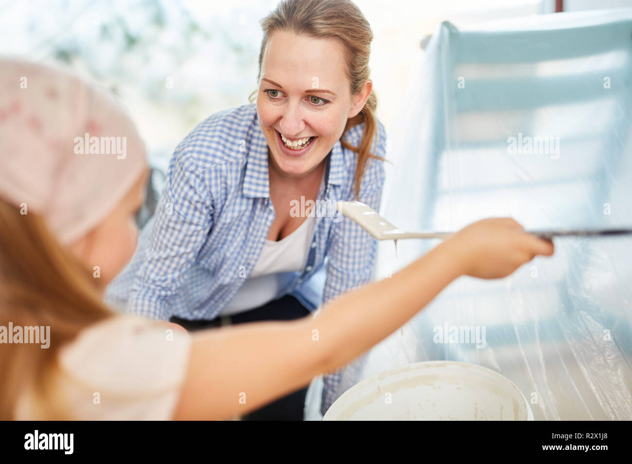 Lachen, Mutter und Kind als Heimwerker beim Malen im neuen Zuhause Stockfoto