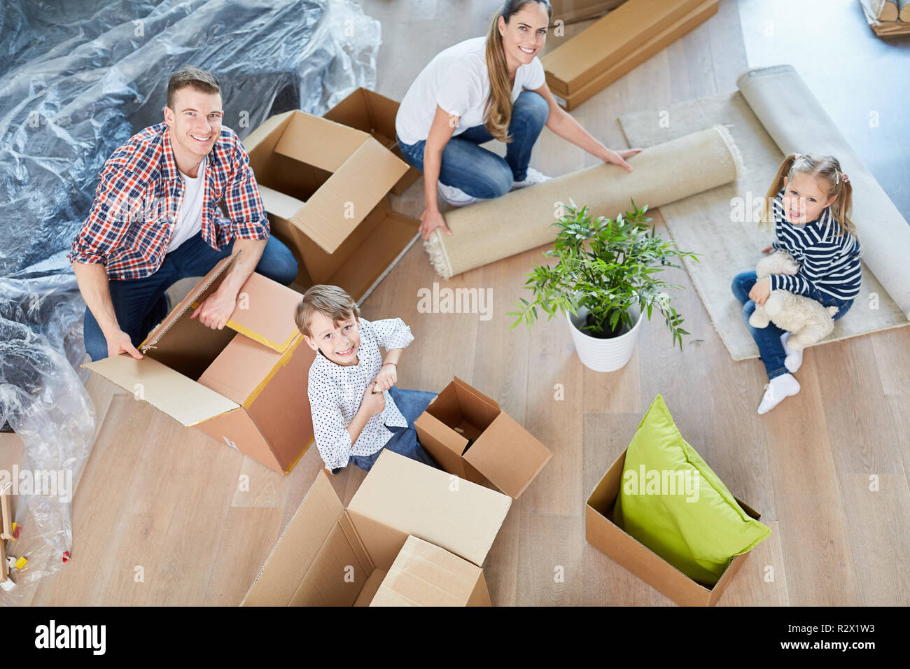 Familie und zwei Kinder Packen verschieben Boxen in Ihrer neuen Heimat Stockfoto