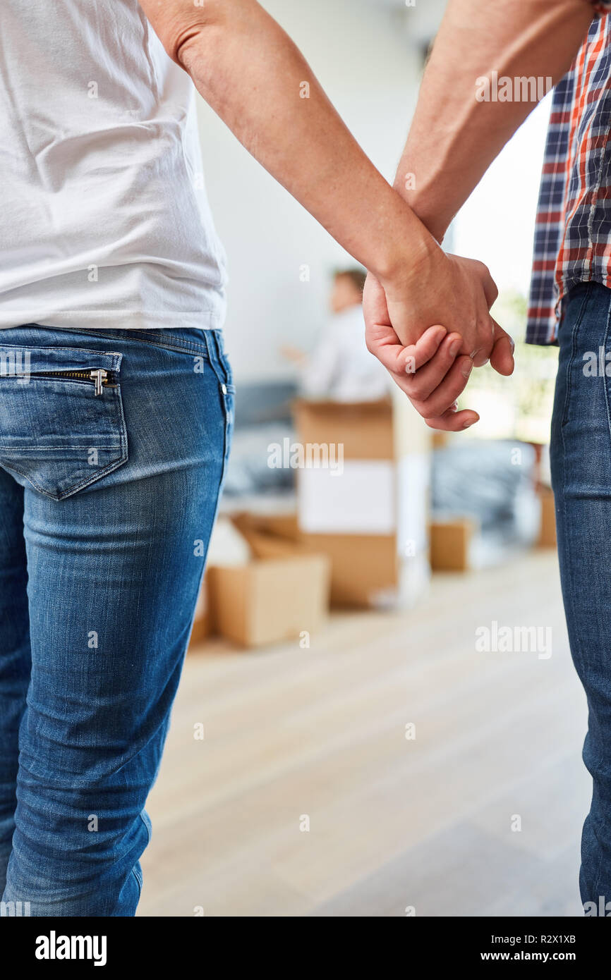 Glückliches Paar hält Hände beim Umzug in das neue Haus als Heim Stockfoto