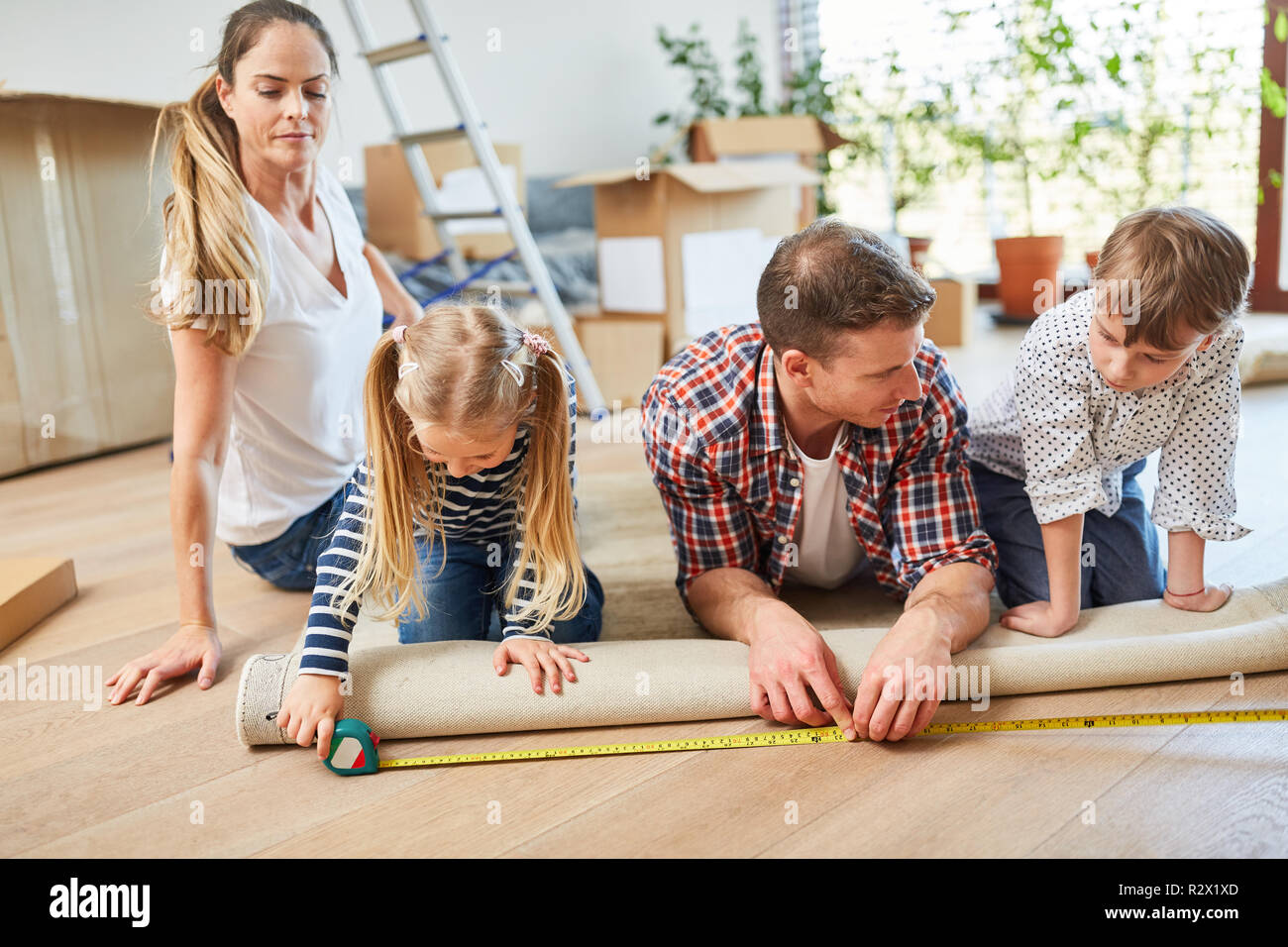 Eltern und zwei Kindern ein Teppich in das neue Haus als Heim Stockfoto