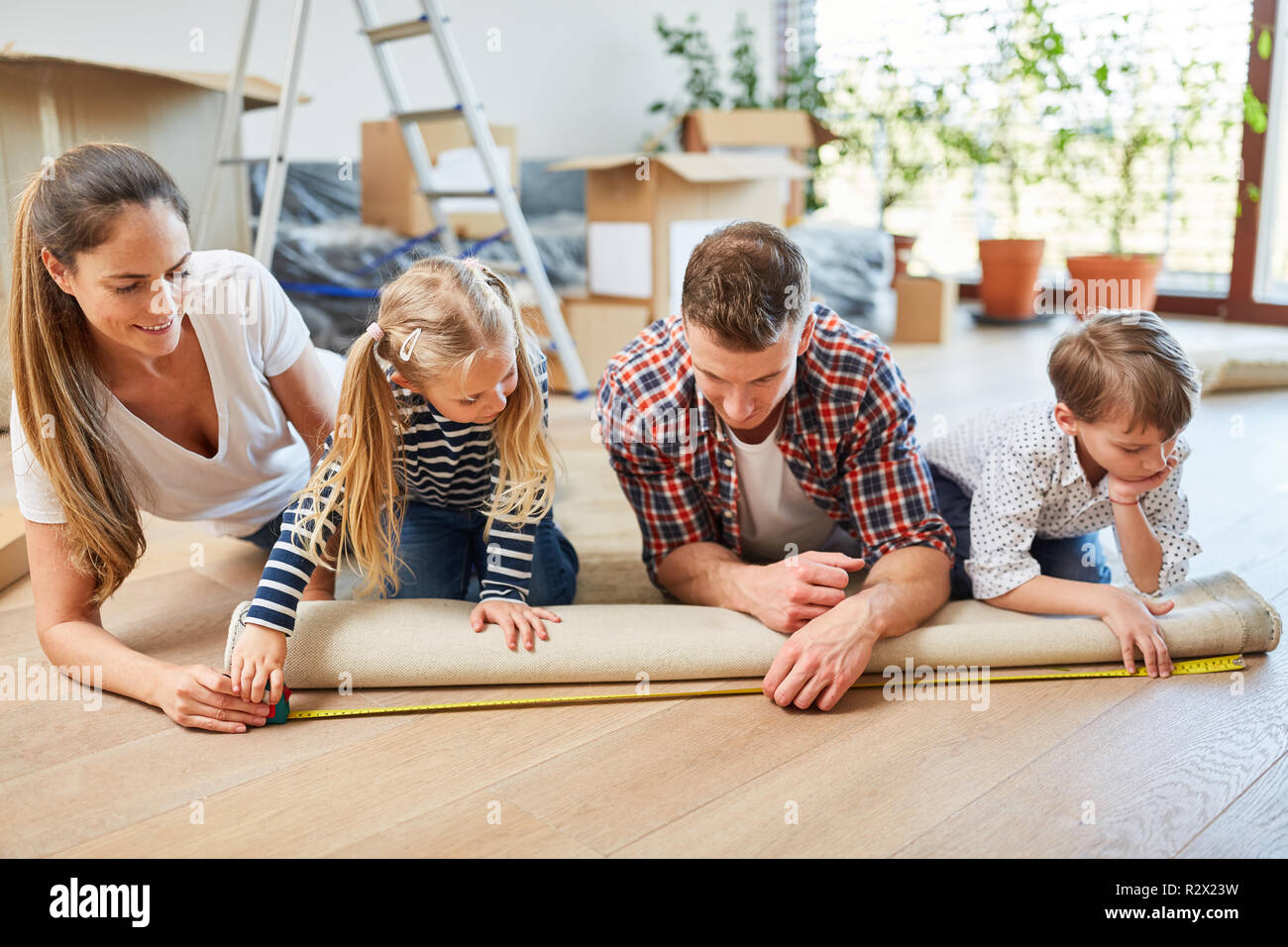 Eltern und zwei Kindern eine Wolldecke messen, während der Einrichtung eines Heimnetzwerks Stockfoto