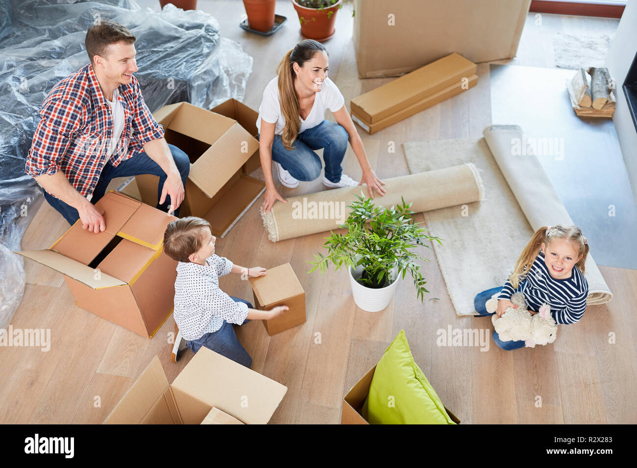 Eltern und zwei Kindern in ihrem neuen Zuhause Verpackung Kisten Stockfoto